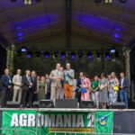 Grupa ludzi na scenie festiwalowej.