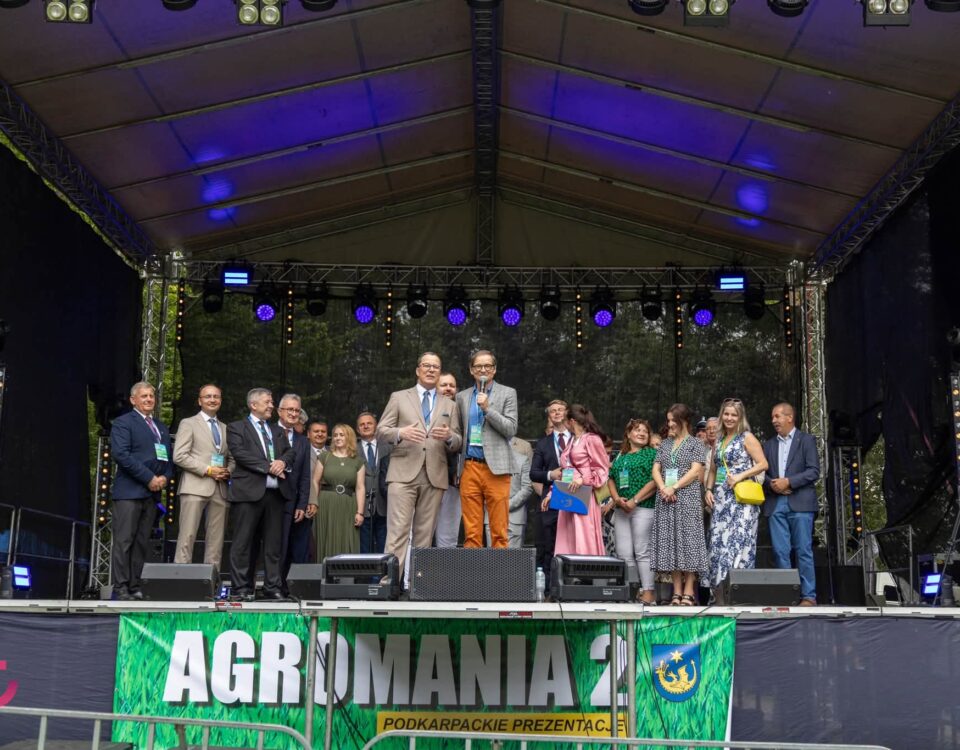 Grupa ludzi na scenie festiwalowej.